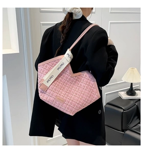Pink tweed tote bag detail with heart-shaped top edge and white canvas shoulder strap