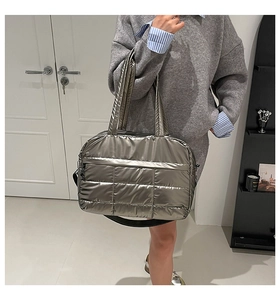Sac fourre-tout matelassé argenté avec fini métallisé et bandoulière porté par mannequin