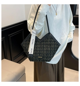 Detail of checkered tweed tote bag with V-shaped opening and gold brand plaque