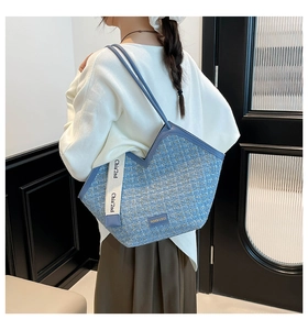 Detail of blue tweed tote bag showing gold threading and Chia'2nd woven ribbon accents