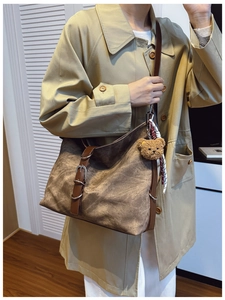 Detailed view of a retro large tote bag with brown plush bear charm and adjustable strap