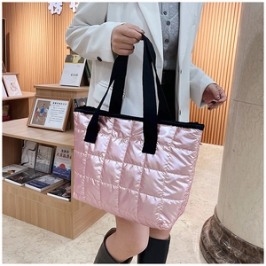 Détail du sac cabas matelassé rose métallisé avec de larges anses noires tissées