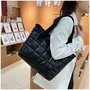 Vue détaillée d'un grand sac cabas matelassé noir porté par un mannequin pour l'hiver