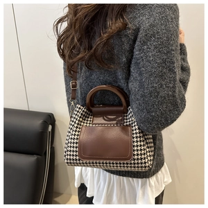 Détail du sac à main vintage à motif pied-de-poule avec bordure en cuir marron