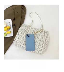 Kapazitätsansicht der weißen Tweed-Beuteltasche mit Perlenanhänger und Smartphone