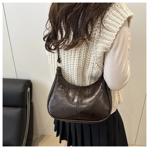 Detail view of the brown oil wax leather texture and stitching on the hobo shoulder bag