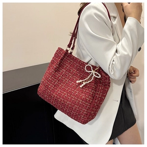 Detail der burgunderroten Tweed-Tasche mit Perlen-Schleife und Lederriemen