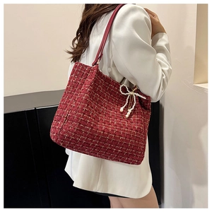 Detail der roten Tweed-Beuteltasche mit Goldfaden und Perlen-Schleifen-Anhänger