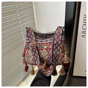 Detail of bohemian jacquard tote bag with colorful woven strap and long side tassels
