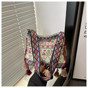 Detail of bohemian jacquard crossbody bag featuring wide straps and colorful tassels