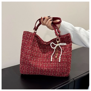 Detail der roten Tweed-Tasche mit gewebten Goldfäden und Perlen-Schleifen-Anhänger