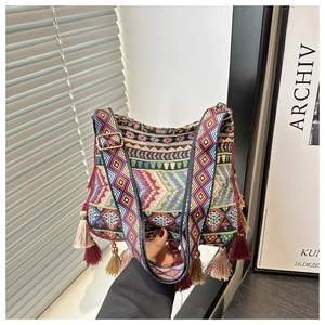 Detail of bohemian woven bag featuring colorful geometric patterns and decorative tassels