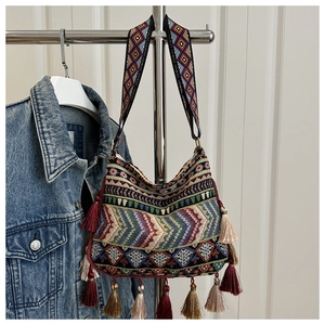Close-up of bohemian canvas bag with multi-color geometric embroidery and fringe tassels