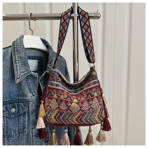 Close-up of Bohemian embroidered shoulder bag featuring colorful tassels and ethnic patterns