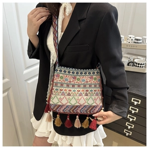 Close-up of ethnic crossbody bag featuring colorful geometric patterns and long tassels