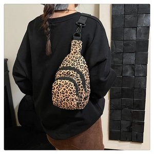 Detail of leopard print crossbody bag with dual zippers and adjustable nylon strap