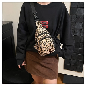 Close-up of leopard print crossbody bag with multiple zippers and adjustable strap