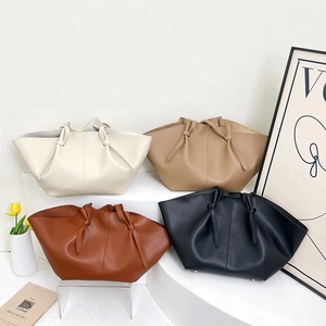 Chic winged tote bag in pebbled leather with knotted handle available in four classic colors