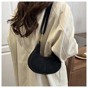 Minimalist black hobo bag in matte finish with gold buckle details on the shoulder strap
