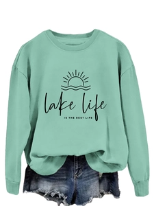 Detail of lake life print on a mint green crewneck sweatshirt and denim shorts