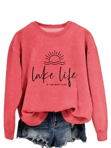 Close-up of coral pink sweatshirt with lake life graphic and denim shorts detail