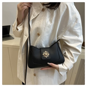 Close-up of black PU leather shoulder bag featuring an elegant vintage gold floral buckle