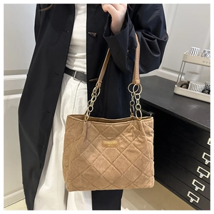 Close-up of quilted suede texture and golden chain strap on large khaki tote bag