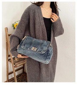 Detailansicht der blauen Denim-Umhängetasche mit silberner Metallkette und Drehverschluss