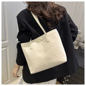 Detail of a minimalist off-white tote bag with golden 'FASHION' lettering on the side