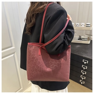Close-up of burgundy leopard print tote bag featuring matte texture and slim shoulder straps