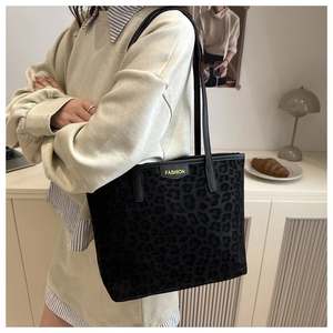 Detailed view of black leopard print plush tote bag with FASHION label and thin straps