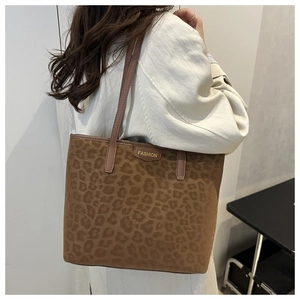 Detail shot of the faux suede brown leopard print tote bag with a golden Fashion tag