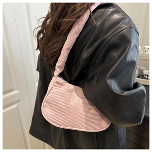 Detailed close-up of pink corduroy shoulder bag featuring a white embroidered bow design