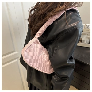 Détail du sac porté épaule en velours côtelé rose avec broderie nœud blanc et plis soyeux