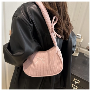 Détail du sac en velours côtelé rose avec broderie nœud blanc et bandoulière nouée