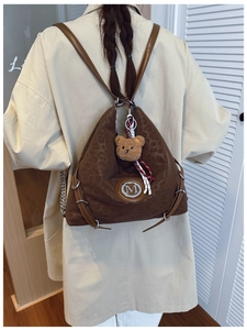 Detail of leopard print backpack with silver M logo and plush bear charm on back