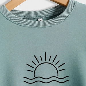 Light teal Lake Life sweatshirt with sunrise graphic on a wooden hanger, size M