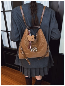 Detail of leopard print tote bag with metal M logo and cute teddy bear charm accessory