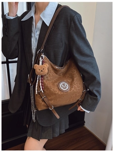 Detail view of leopard print shoulder bag with M metal logo and cute plush bear charm