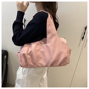 Vista laterale della borsa tote rosa a pieghe su modella che mostra capienza e texture
