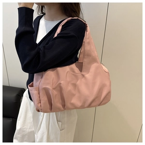 Dettaglio di una borsa tote in nylon pieghettato rosa antico con tasca laterale e trama