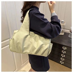 Détail d'un sac cabas plissé en nylon vert clair avec poche latérale et fermeture éclair