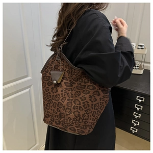 Close-up of leopard print tote bag featuring a leather strap and small triangle pouch