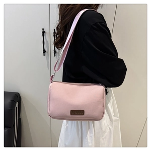 Détail du sac bandoulière rose résistant à l'eau avec patch FASHION et large sangle
