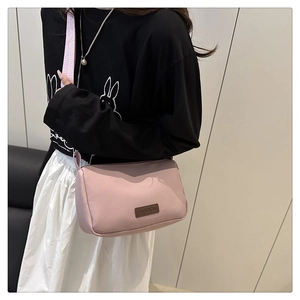 Sac à bandoulière rose imperméable avec étiquette FASHION porté par un mannequin