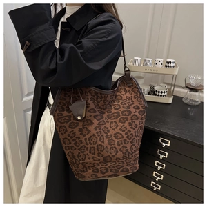 Close-up of large leopard print bucket bag with leather strap and suede texture