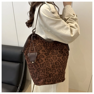 Vista dettagliata della borsa tote leopardata con cinturini in pelle su una modella in stanza