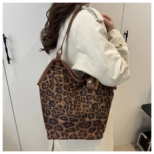 Dettaglio della borsa tote leopardata con manici in pelle marrone e trench coat beige