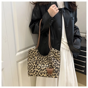 Dettaglio della borsa tote scamosciata leopardata con manici in pelle sul modello