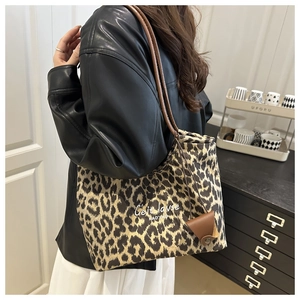 Dettaglio della borsa tote scamosciata leopardata con manici in pelle marrone